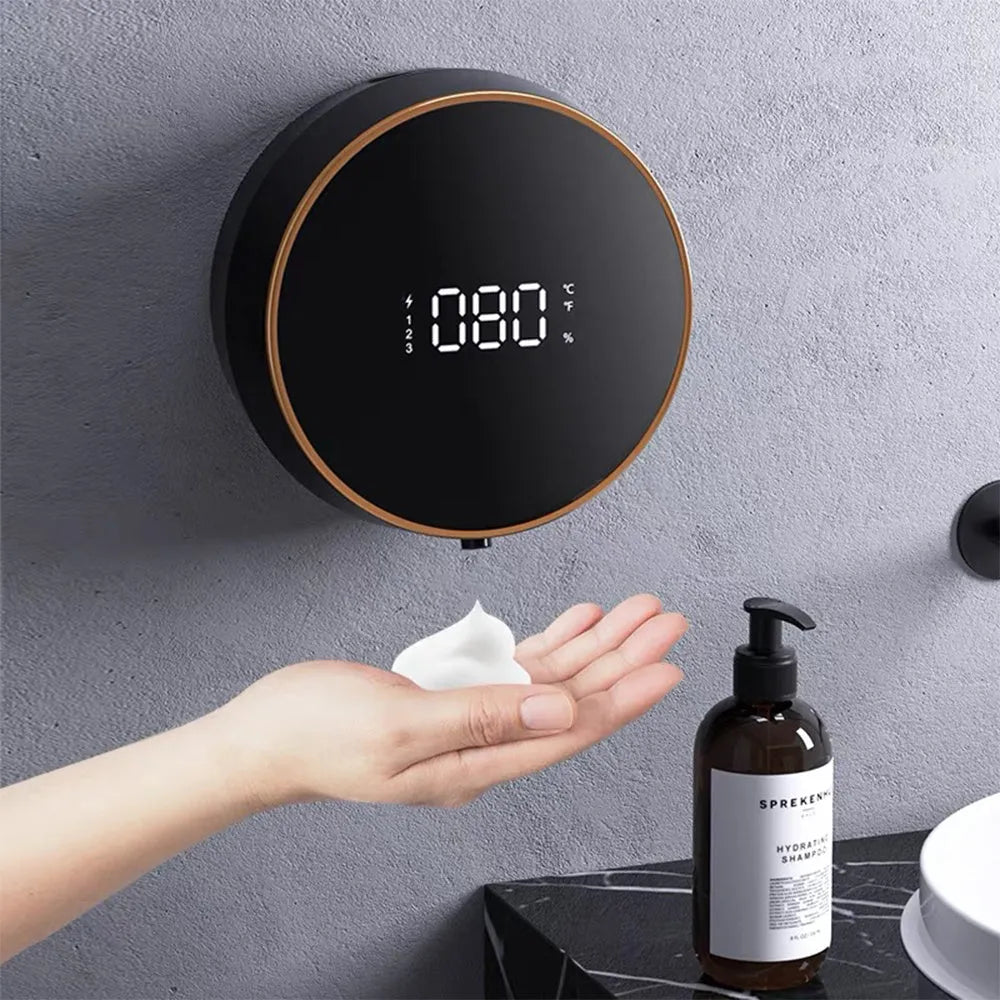 Black automatic sensor foam soap dispenser mounted on a wall with a USB cable connected.