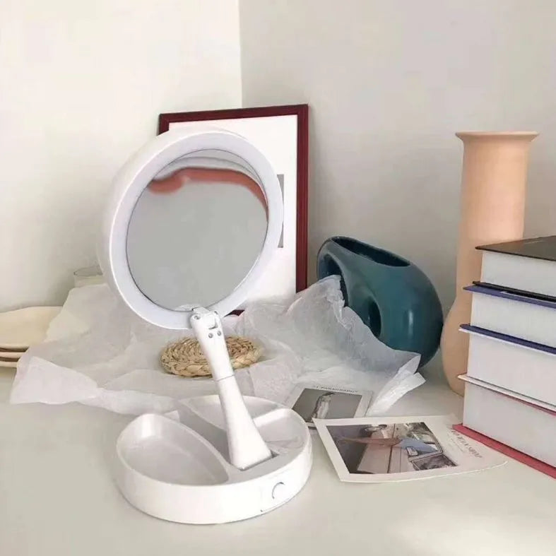 White acrylic LED vanity mirror with foldable base and storage compartment, shown unfolded on a table.