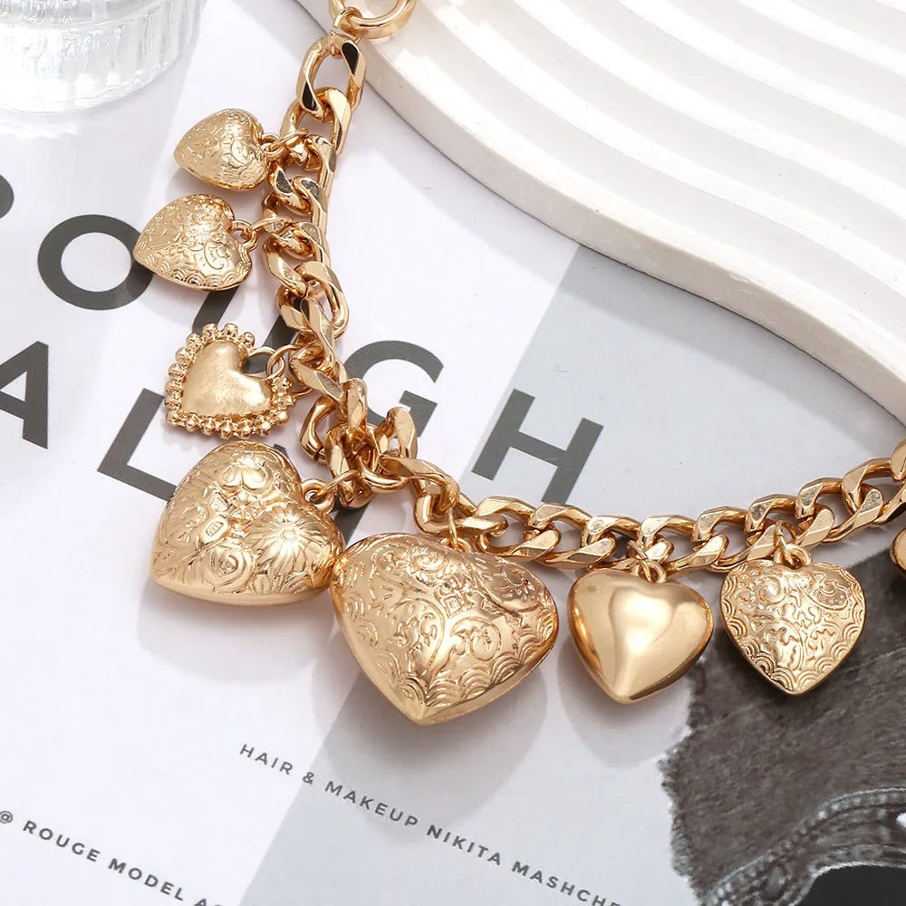 Gold carved heart-shaped pendant necklace on an adjustable metal chain.