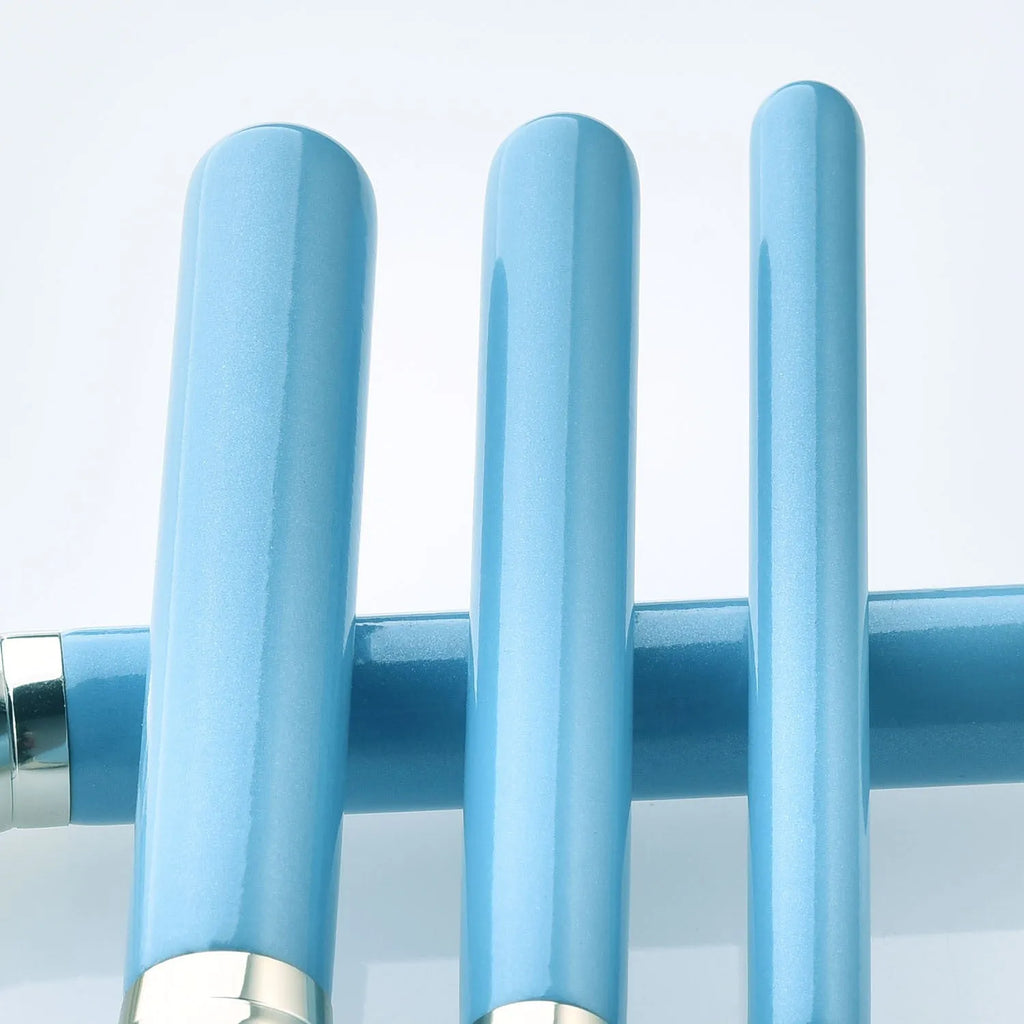 Blue 13-piece synthetic hair makeup brush set with wooden handles and aluminum ferrules on a clean surface