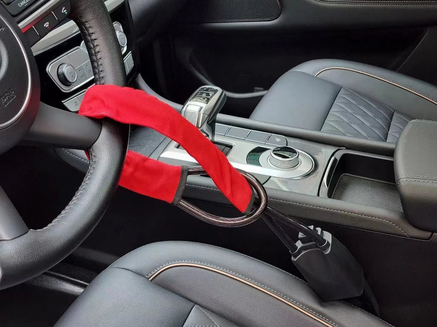 Red iron car steering wheel lock for General Motors vehicles on a steering wheel.