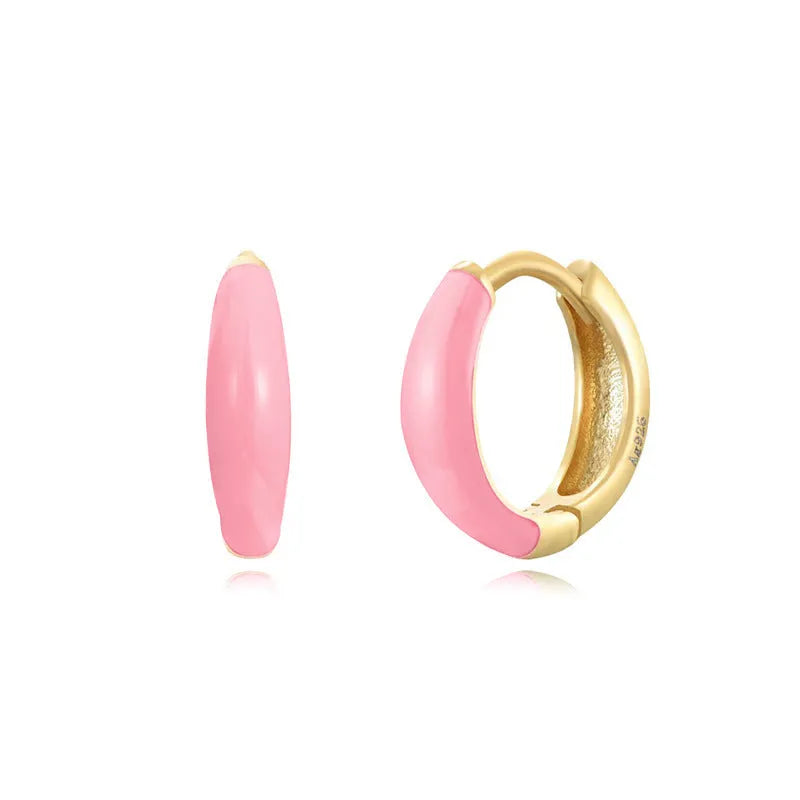 A pair of glossy light green epoxy oval earrings with a U-shaped curve and silver-coloured post on a grey background.