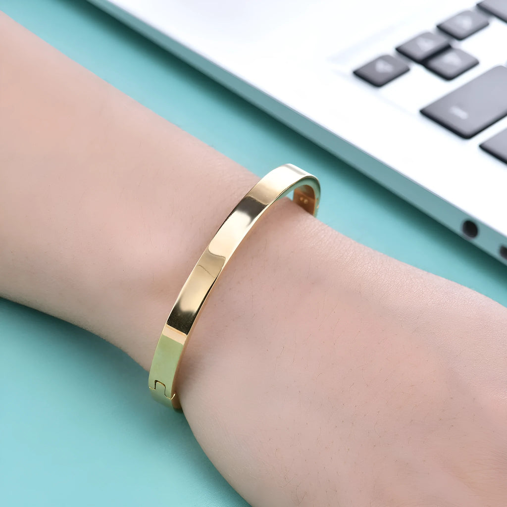 Stainless steel snap bracelet with polished finish in gold colour on a white background