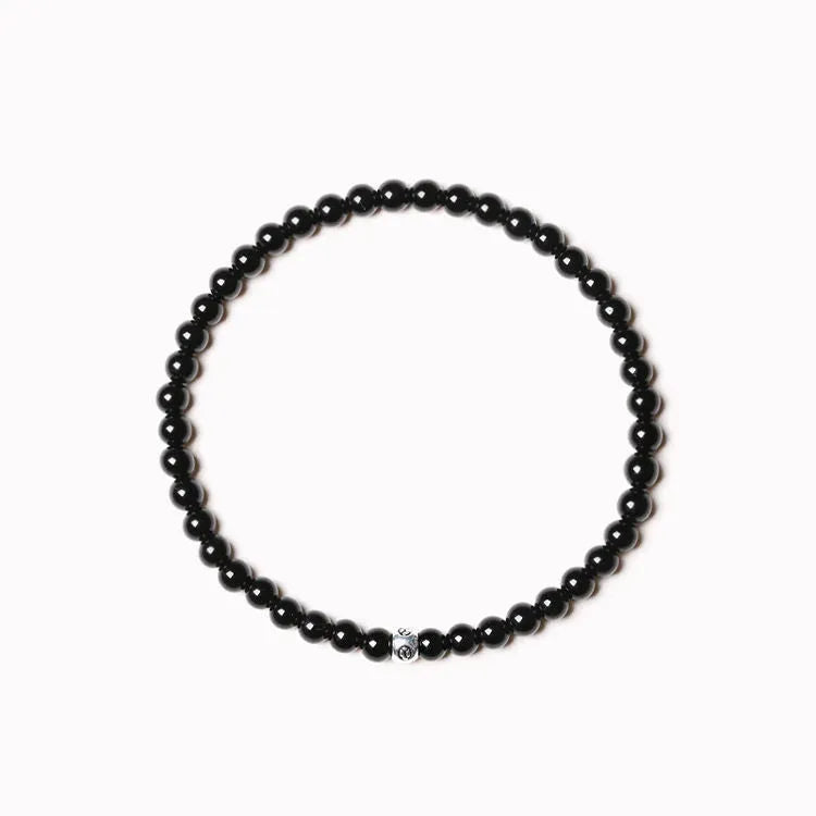A unisex geometric bracelet with round and square obsidian, blue San and agate beads on a black background.