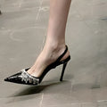 Black women's slingback high heel sandals with rhinestone and tassel decoration on a pointed toe.