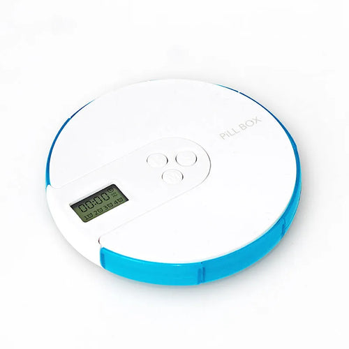 Blue seven-compartment electronic pill box with digital display and alarm clock, shown next to pills.