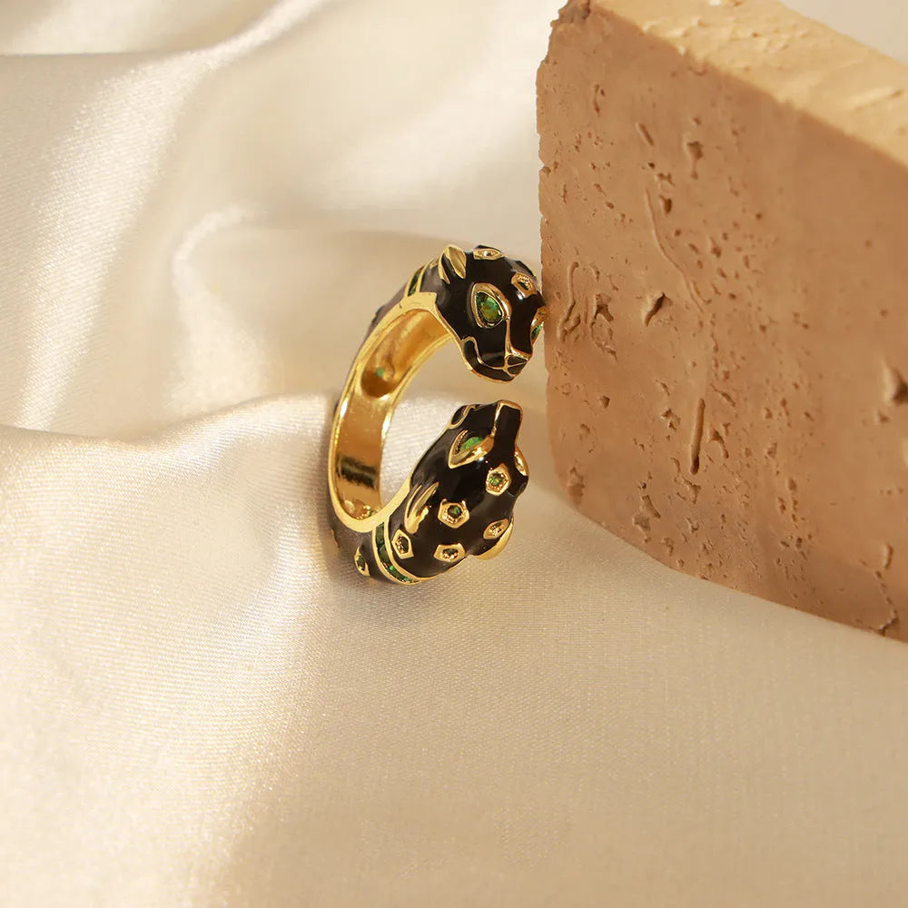 Geometric open fashion ring with a black cheetah print pattern, shown on a model's hand.