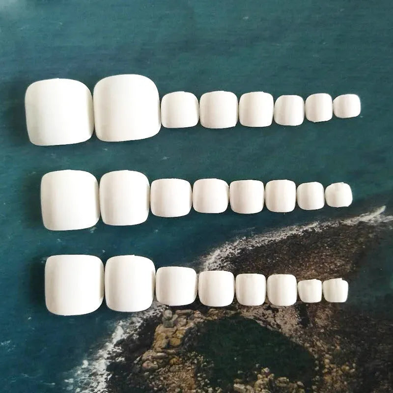 White artificial false toe nails with starry sky pattern, shown as a complete set with glue.
