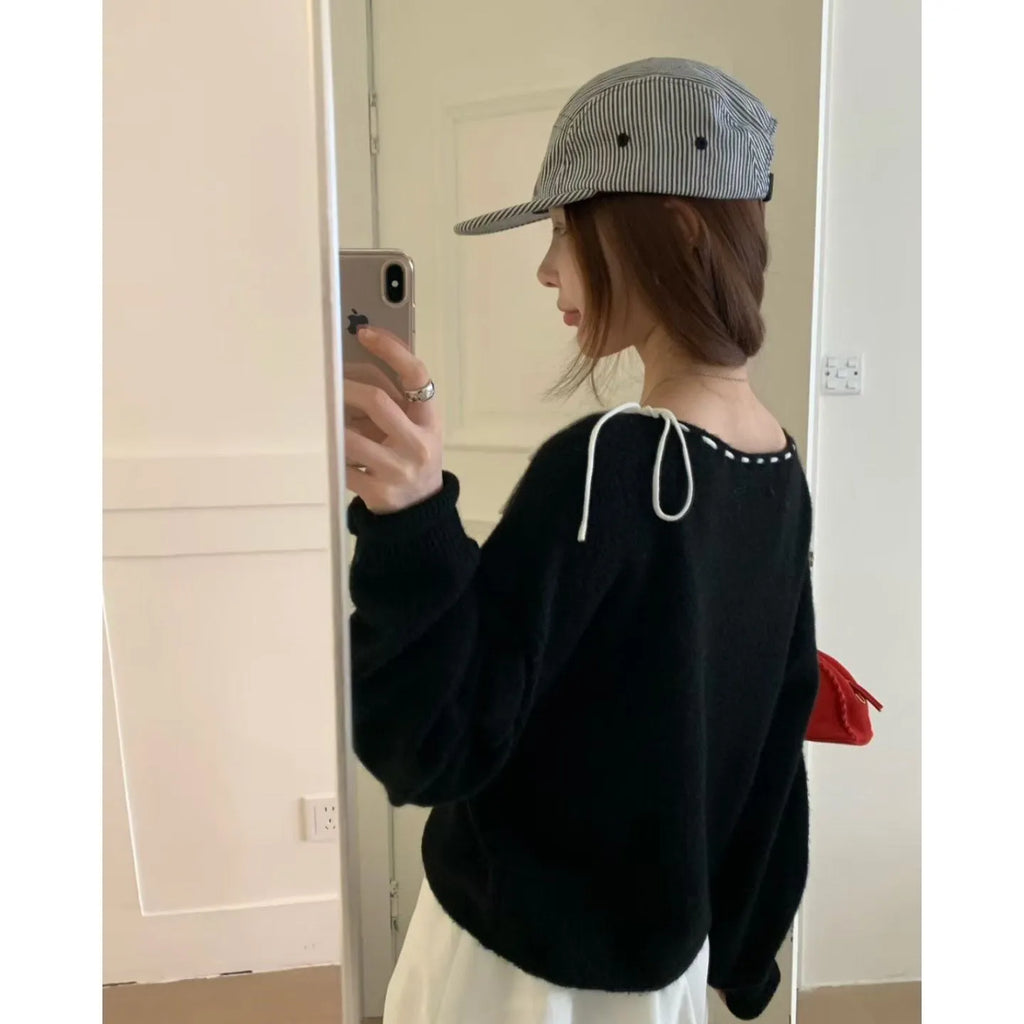 Grey loose-fitting women's pullover knitwear top on a hanger.