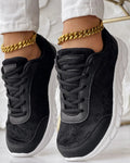 Women's white canvas running shoes with a flat heel and soft sole on a plain background.