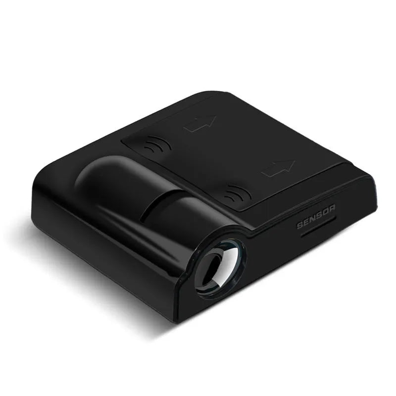 Small black car projection lamp showing front design and battery compartment, next to AA batteries for scale.