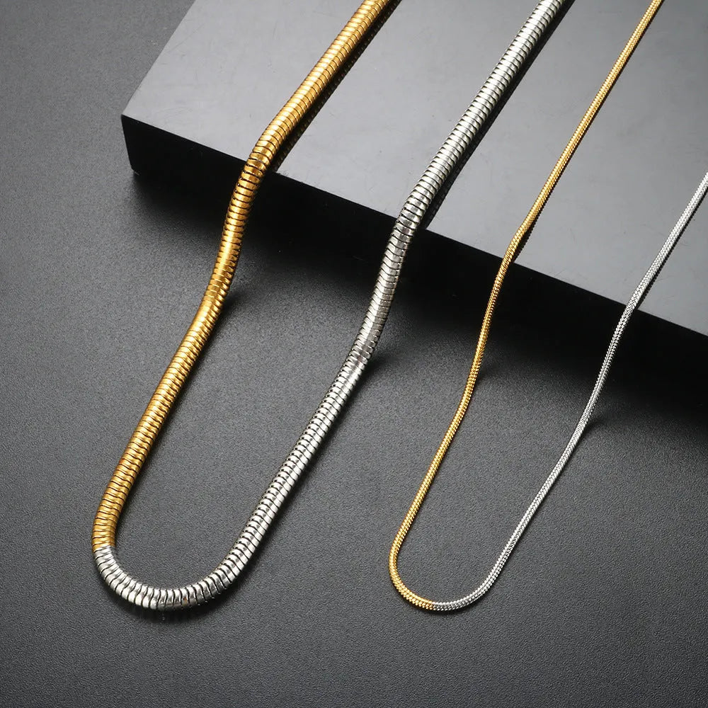 Gold-coloured geometric snake bone chain necklace for women on a white background, showing adjustable extender.