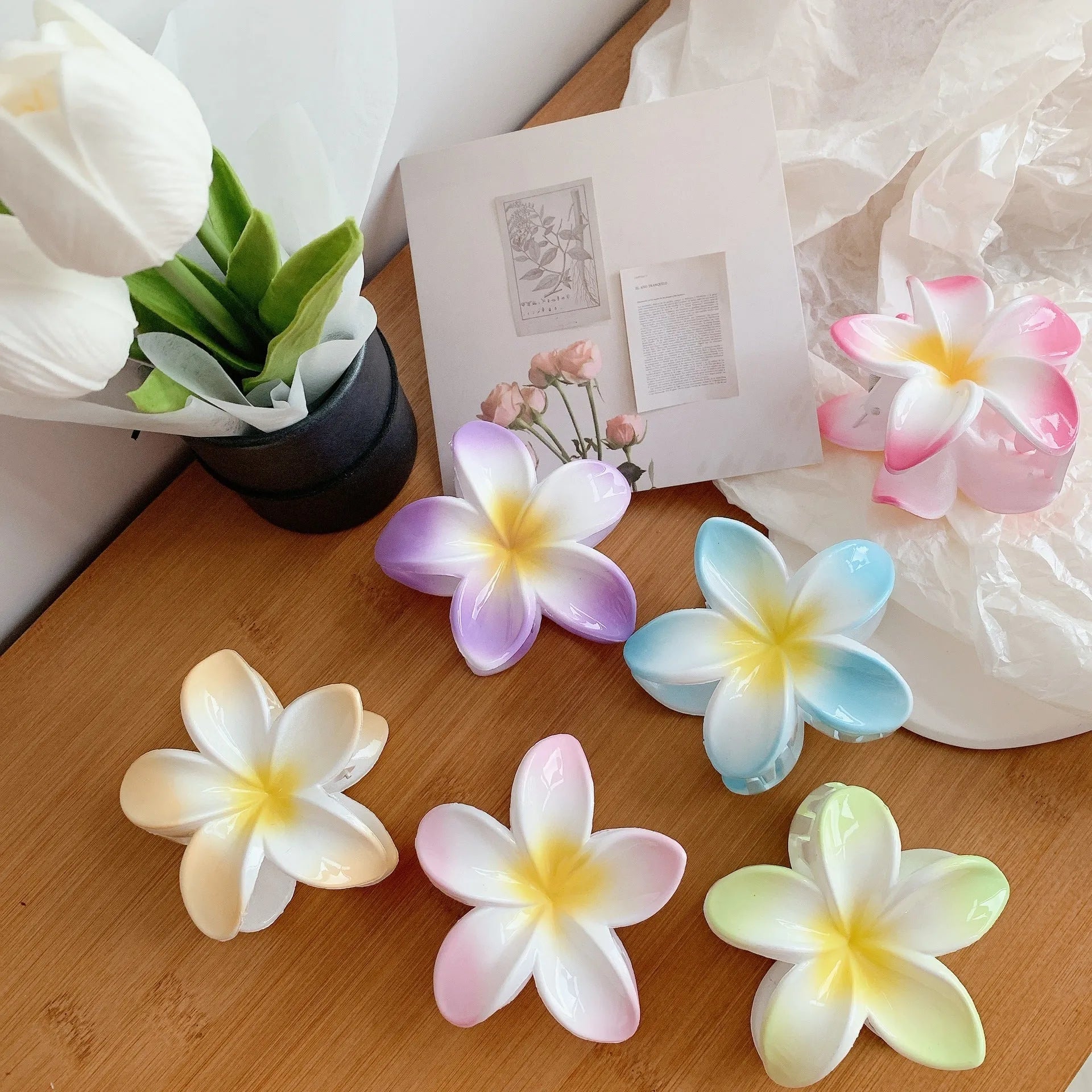 Muweordy plumeria hair claw clip in blue, a decorative flower hair accessory made from plastic and resin.