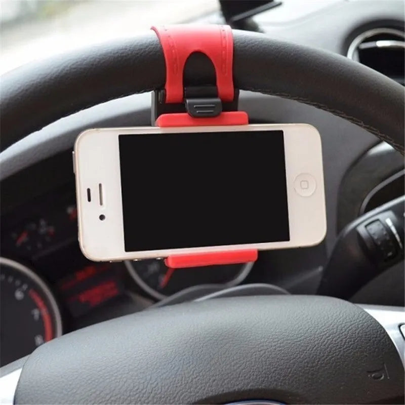 Black universal steering wheel phone holder clip mounted on a car steering wheel, holding a smartphone.
