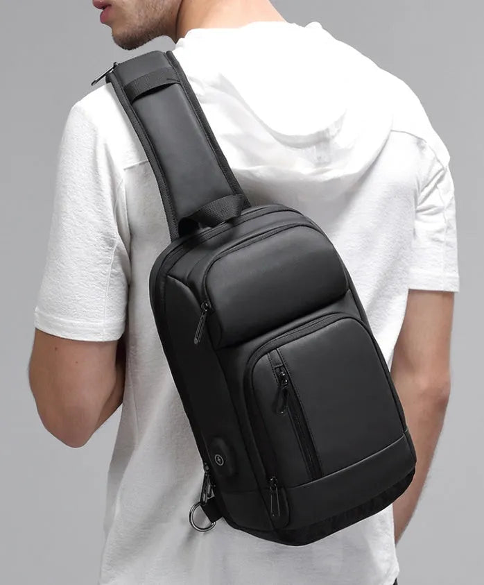 Black square vertical PVC shoulder bag showing organiser pockets and air cushion strap.