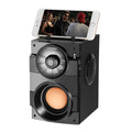Black portable mini audio system with subwoofer and a 1.2m connection cable on a desk.