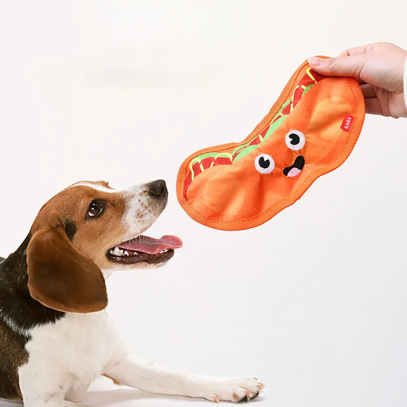 Colourful food-shaped dog toys including a burger, fries, hot dog, and pizza on a white background.