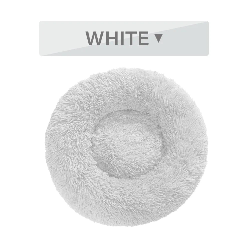 A fluffy, round donut-shaped dog bed with a raised rim in long plush fabric.