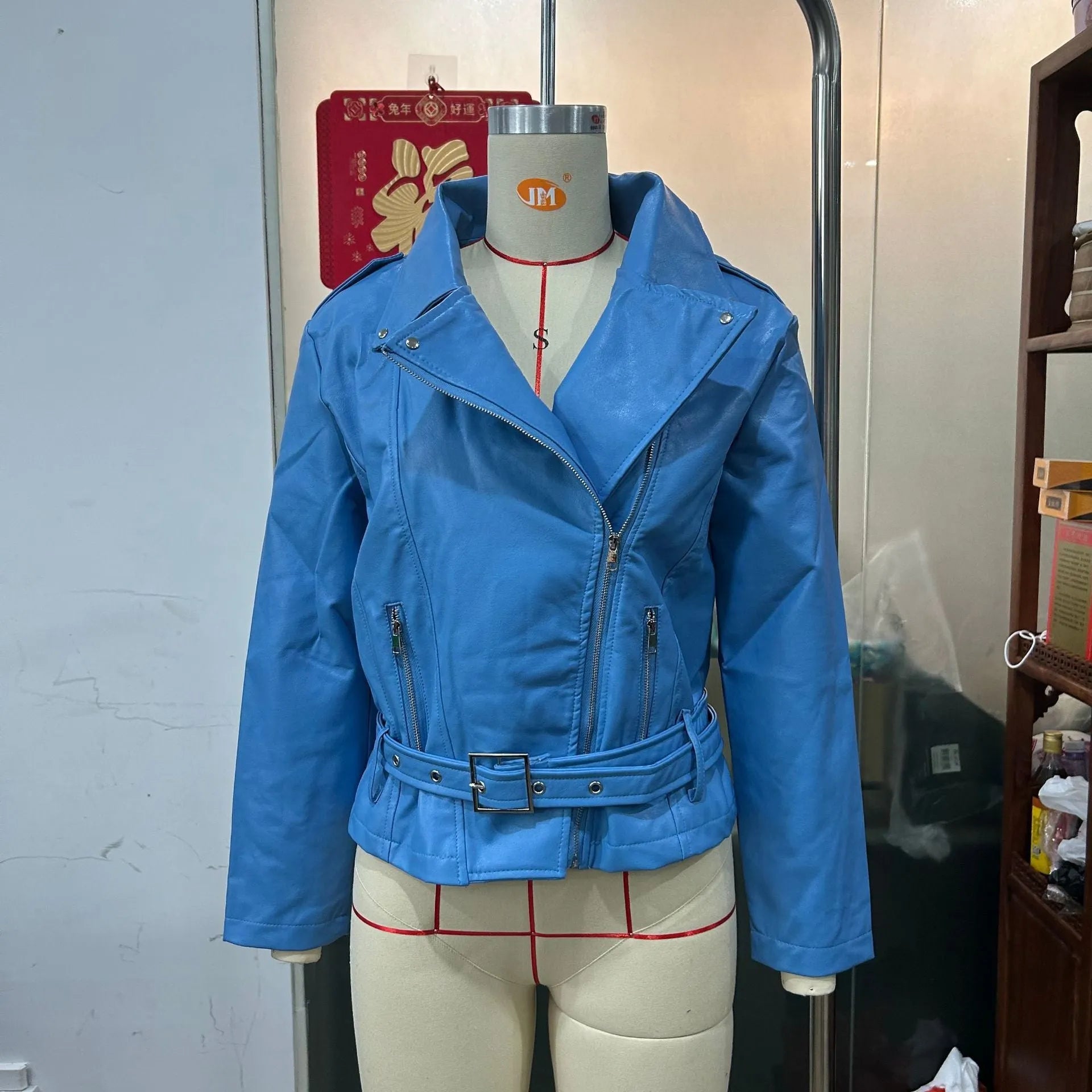 Black punk style leather jacket with a Peter Pan collar and regular sleeves on a hanger.