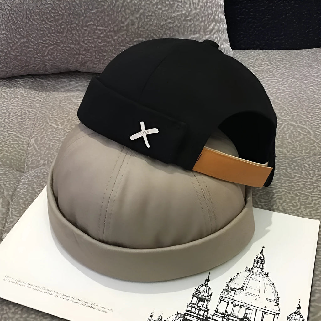 Cotton baseball cap with adjustable buckle in black showing letter pattern and rivet details