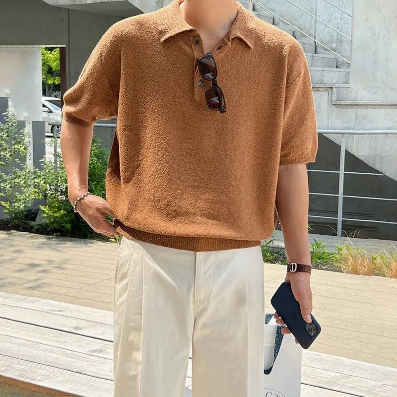 A caramel coloured men's loose-fit knitted polo shirt with short sleeves on a hanger.