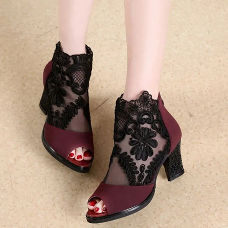 Women's black lace gladiator sandals with square heels and floral patterns, showing zip closure and peep toe design