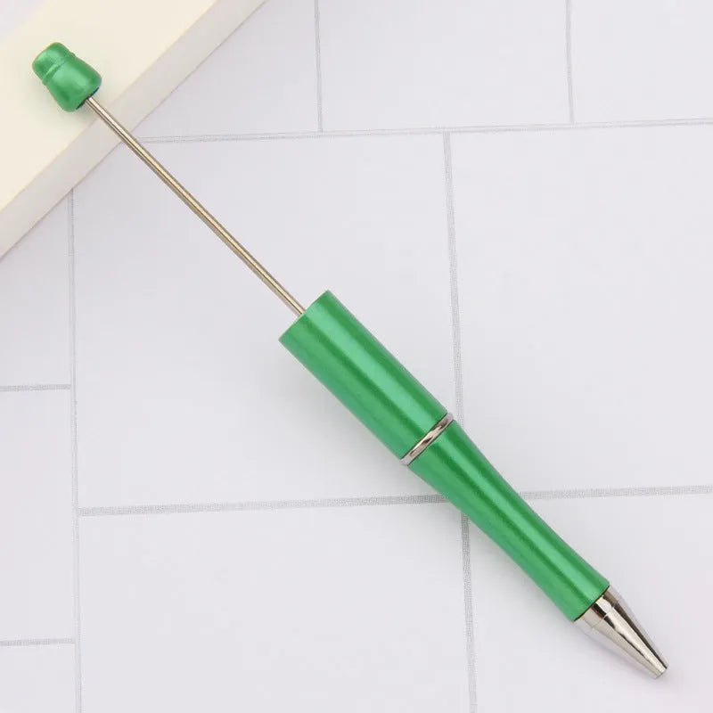 Colourful spinning ballpoint pen with plastic beads on a white background.