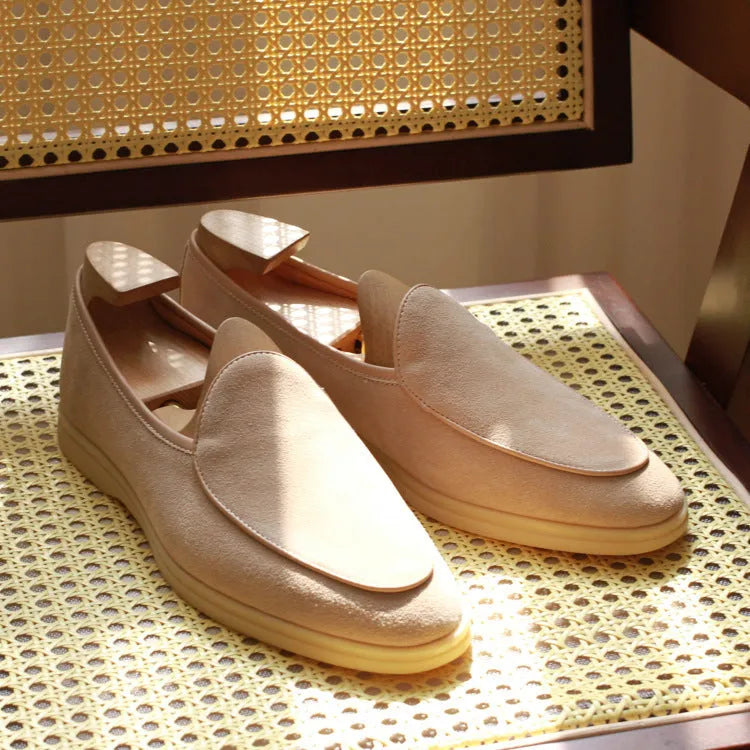 British handmade men's brown leather loafers with a flat TPR sole on a white background.