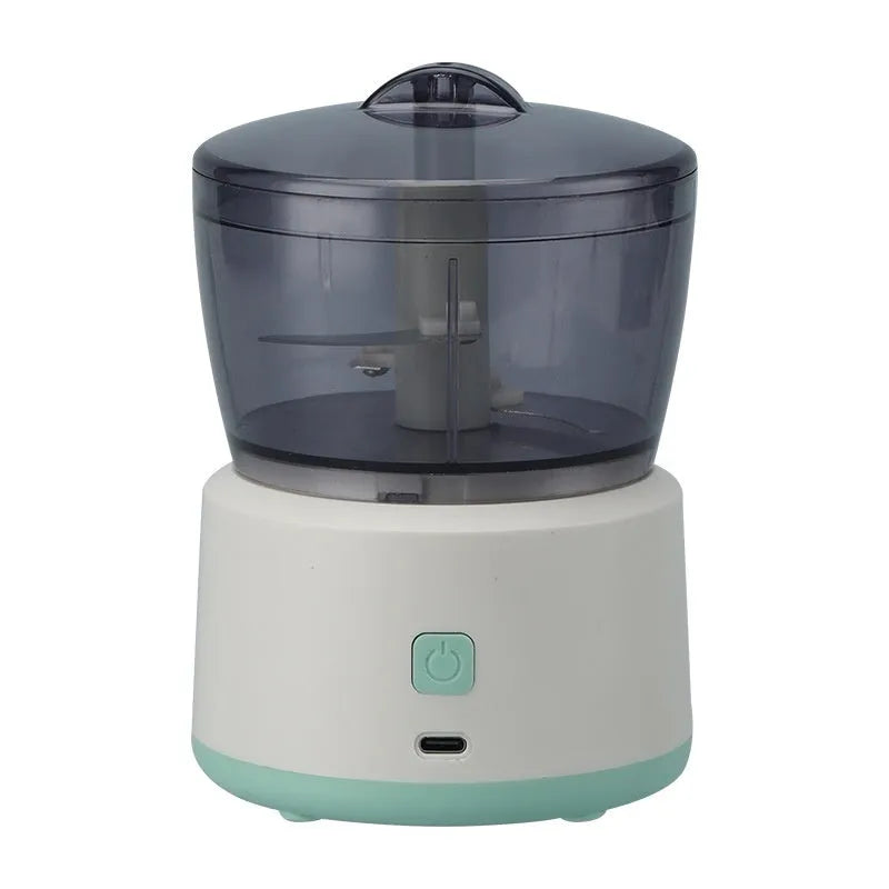 White mini electric meat grinder with transparent cup on kitchen countertop