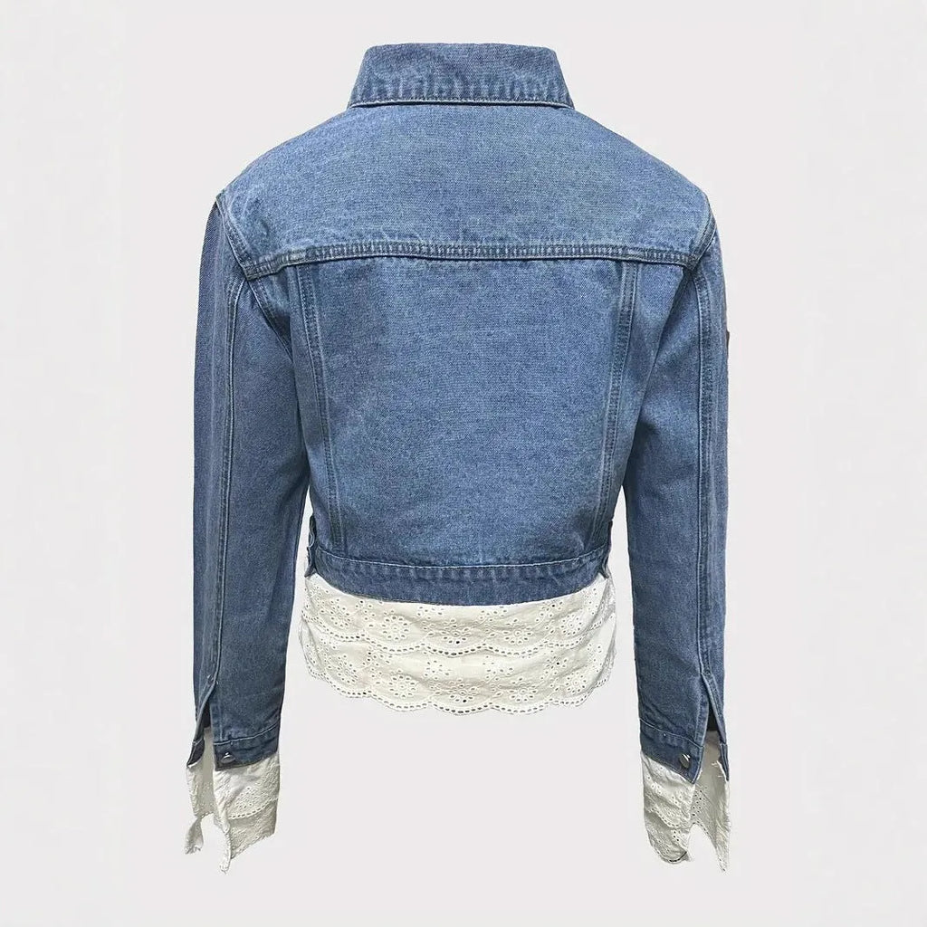 Blue women's denim jacket with lace stitching detail, shown on a hanger.