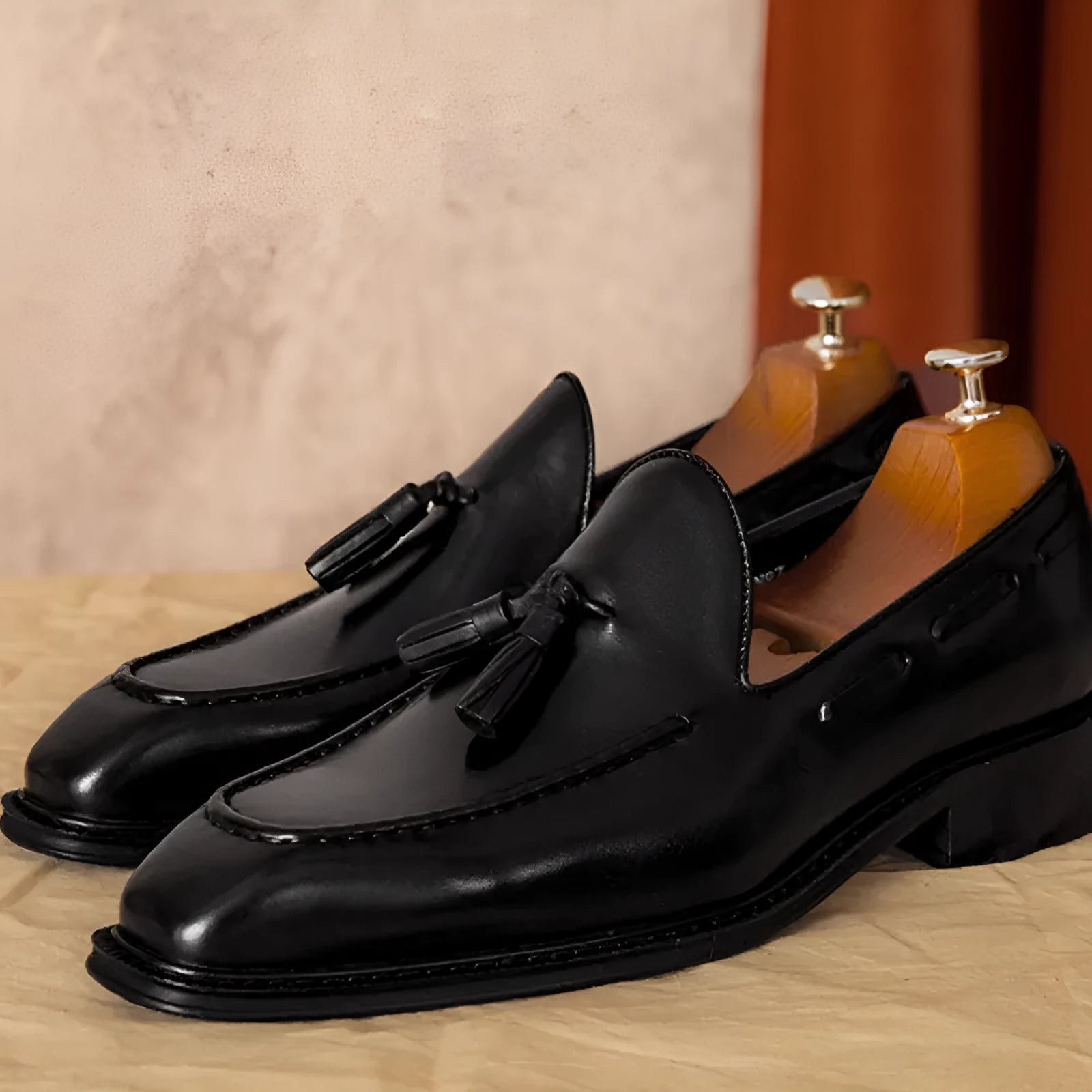 Men's black leather slip-on loafers with fringed detailing and polished finish