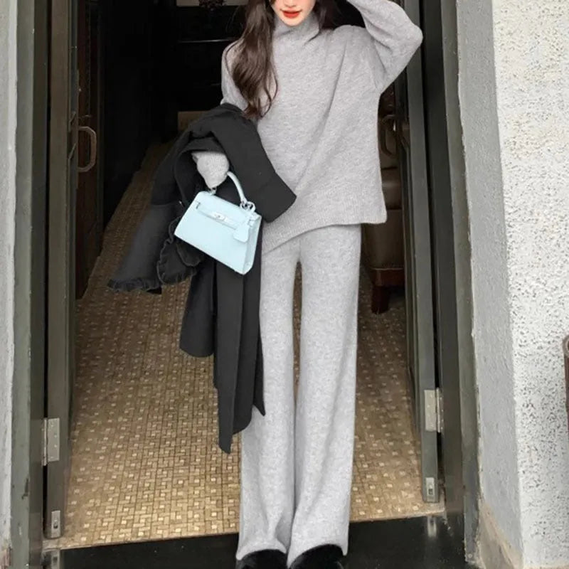 Women's beige acrylic knit sweater and wide-leg trousers two-piece set laid flat.