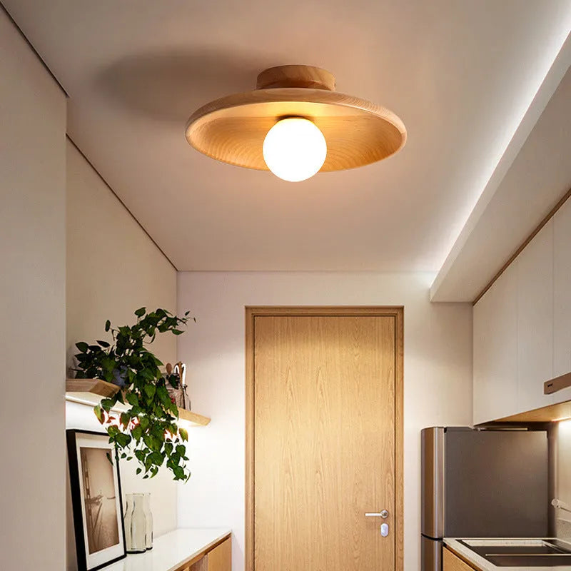 Modern minimalist solid wood and glass ceiling lamp in a hallway setting.