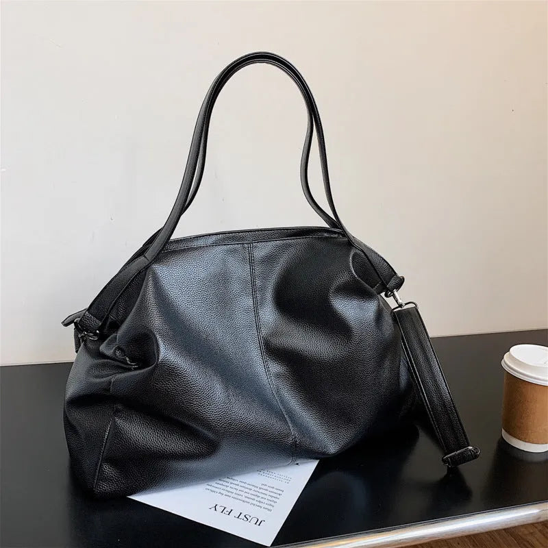 Large horizontal square soft-surface PU leather messenger bag with a long shoulder strap and zip opening.