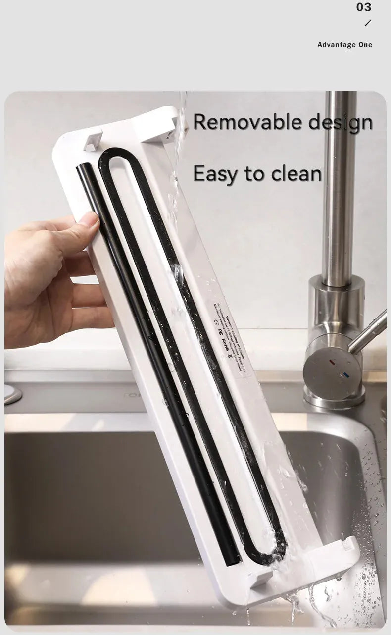 Small black automatic vacuum sealer machine for household food preservation on a kitchen counter