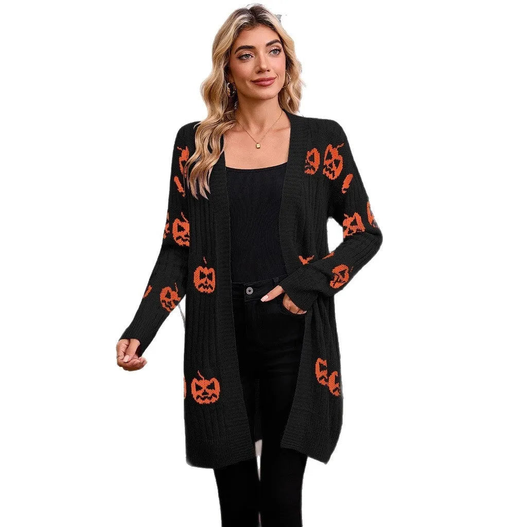 Women's black cardigan with orange pumpkin head jacquard knit pattern, shown as a medium-length coat.