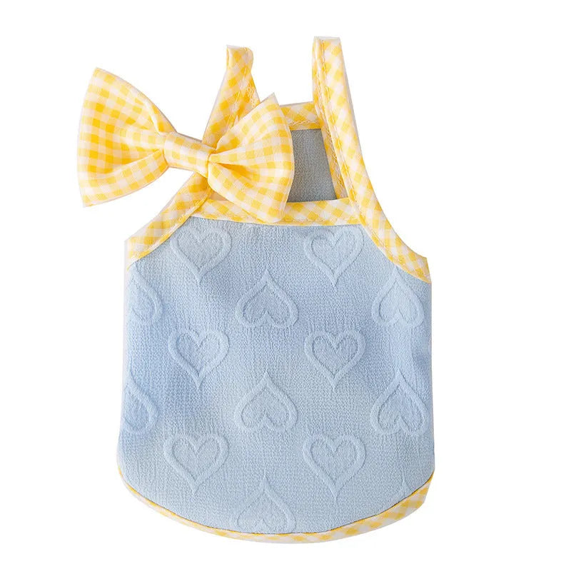 Small dog wearing a blue elastic vest with heart relief texture and bow suspenders.