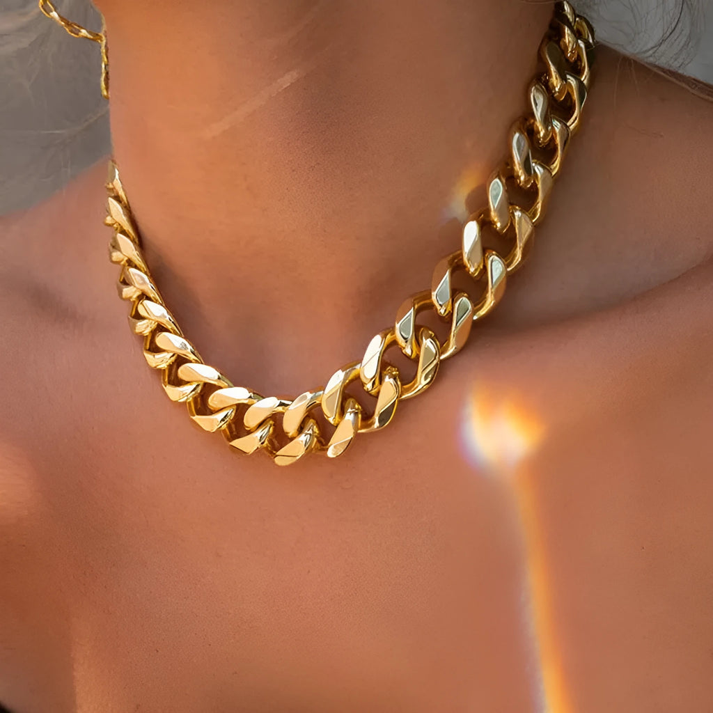 Gold women's thick link chain necklace with a 6cm drop pendant on a model.