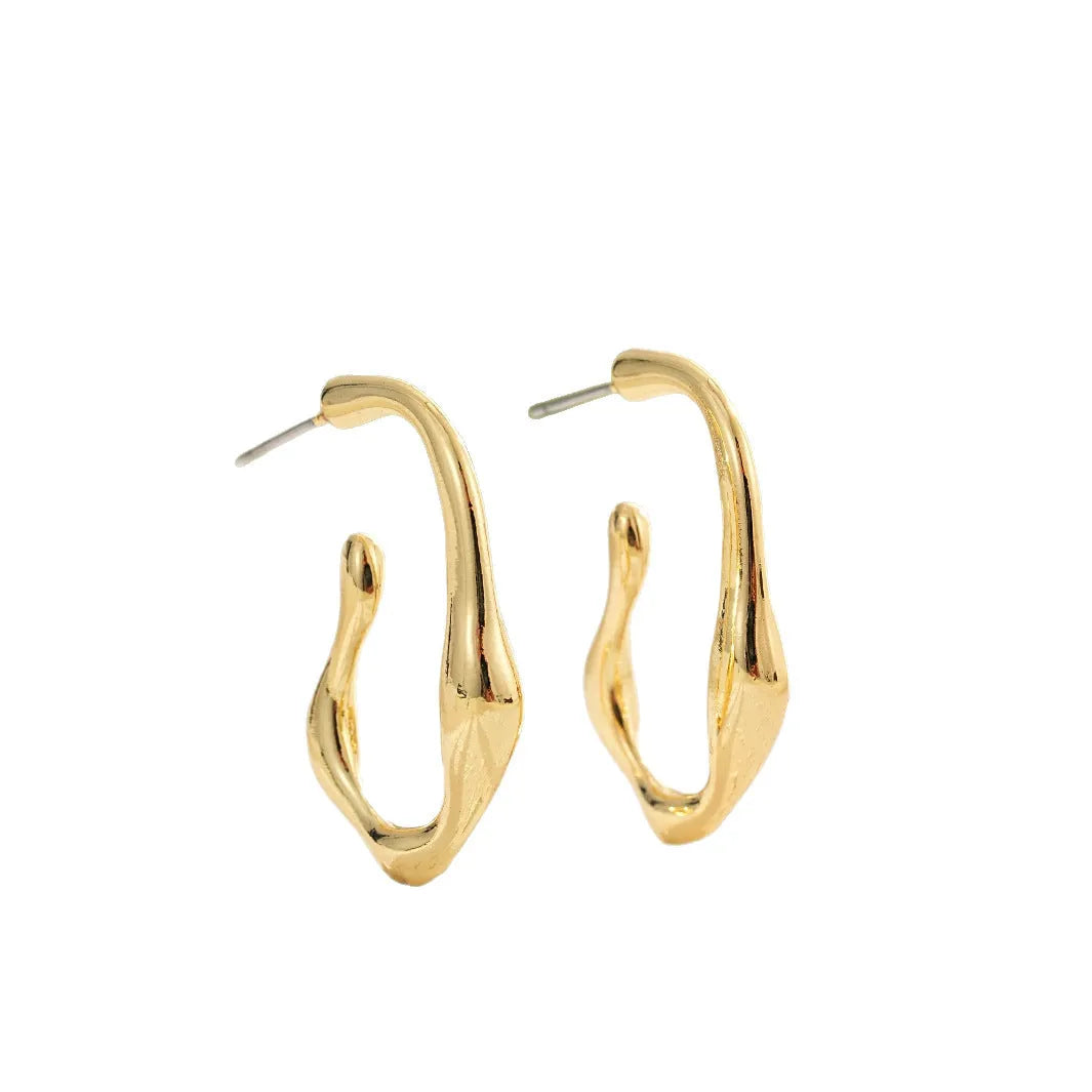 Gold irregular shaped minimalist drop earrings with abstract geometric design on neutral background