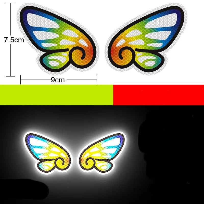 Pair of diamond reflective warning stickers for cars and motorbikes, showing sample designs like a dragon or cat, approx 9 cm by 5 cm.