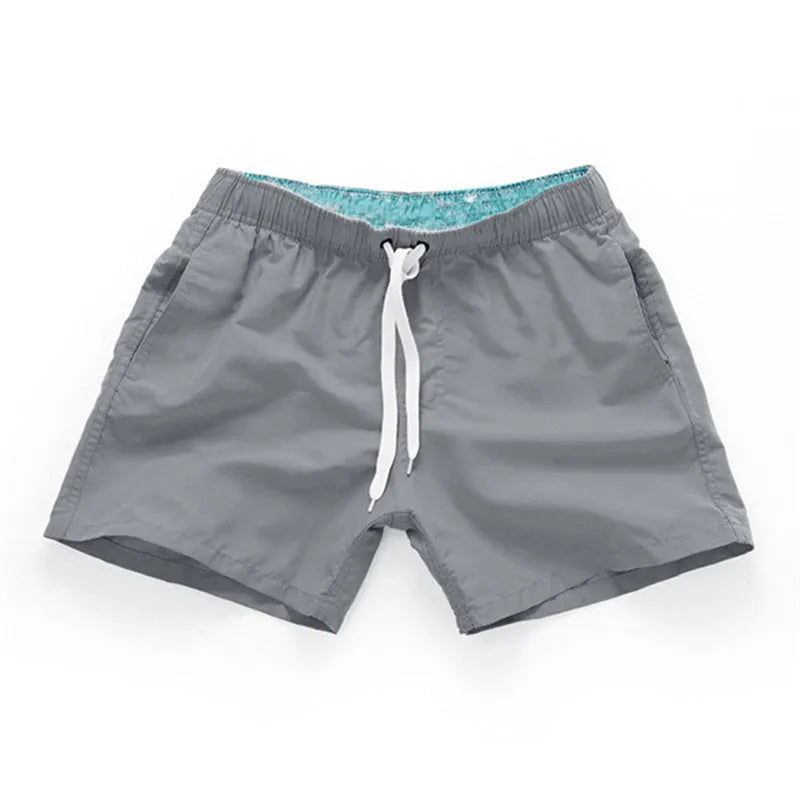 Men's straight-leg polyester beach shorts in black, shown on a model, highlighting the distressed finish and casual fit.