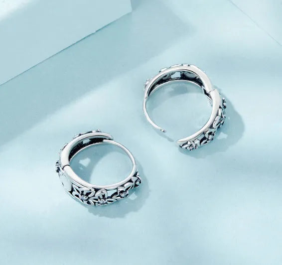 Close-up of retro hollow butterfly shaped stud earrings in sterling silver with zircon stones.