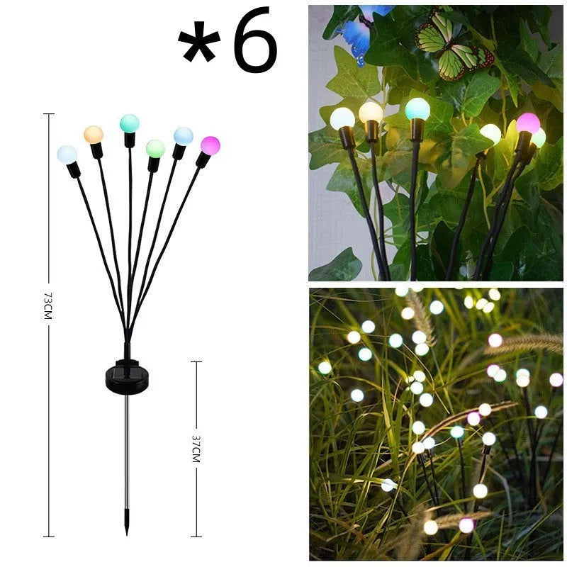 Solar-powered LED firefly garden stake light with stainless steel ground plug illuminated at dusk.