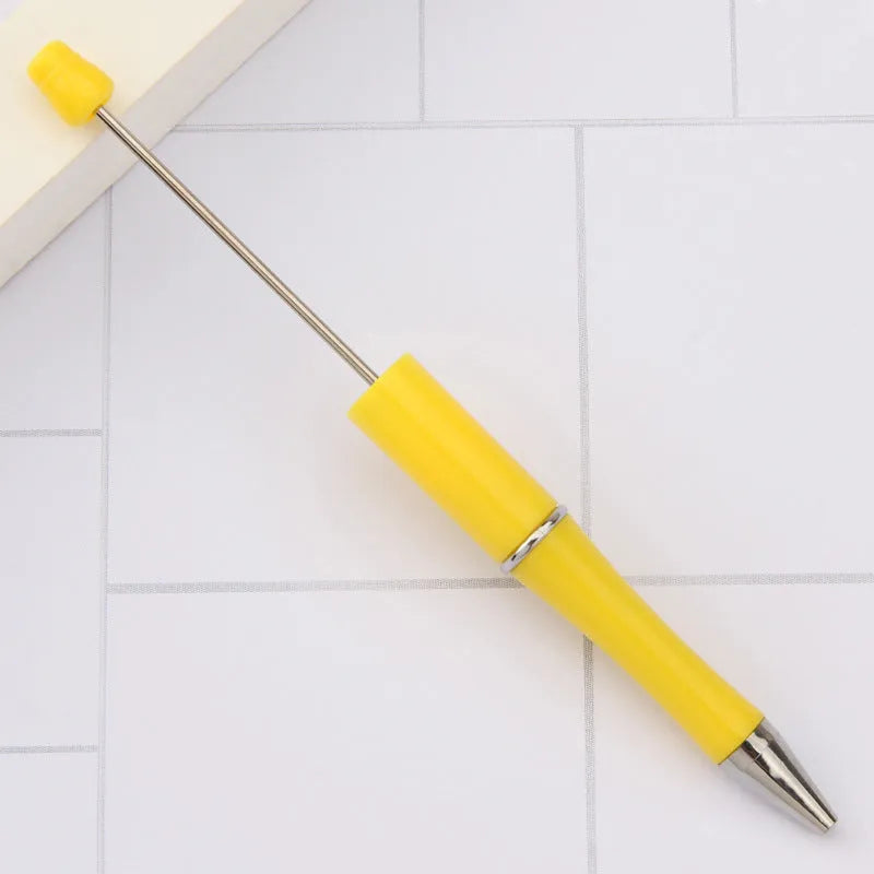 Colourful spinning ballpoint pen with plastic beads on a white background.