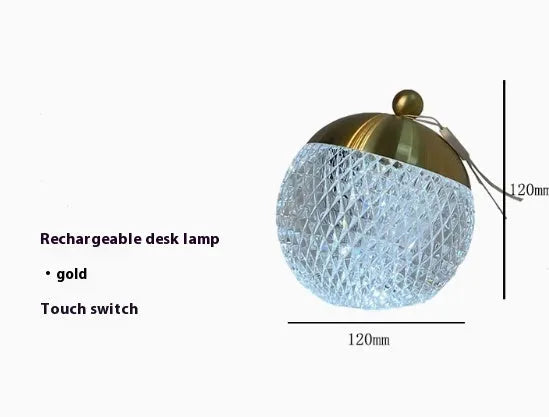 Small portable dimmable night lamp in chrome finish on wooden bedside table