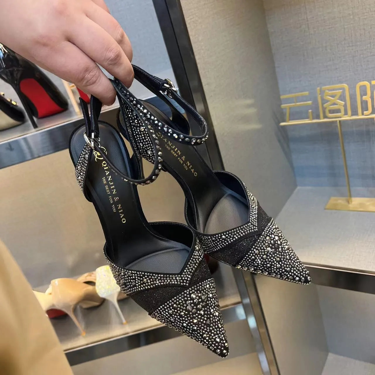 Women's black and silver hollow-cut stiletto heels with a pointed toe and shallow mouth design.