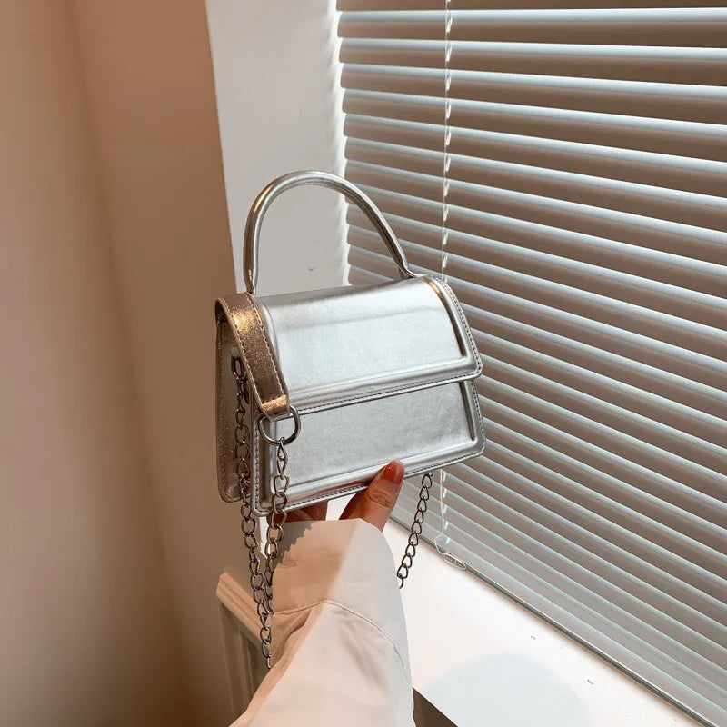 Retro shoulder bag in horizontal square shape with crossbody strap and sewing line detail