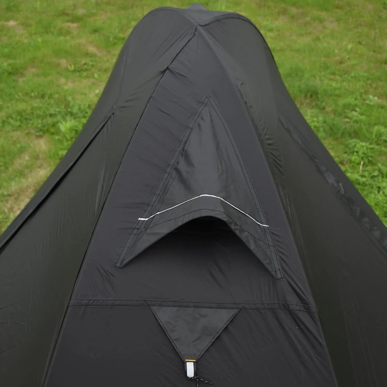 Red single person backpacking tent with aluminium poles pitched in a forest, showing double-layer design and vestibule.