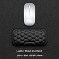 Grey and black memory foam mouse wrist rests with cloth or leather covers on a desk.