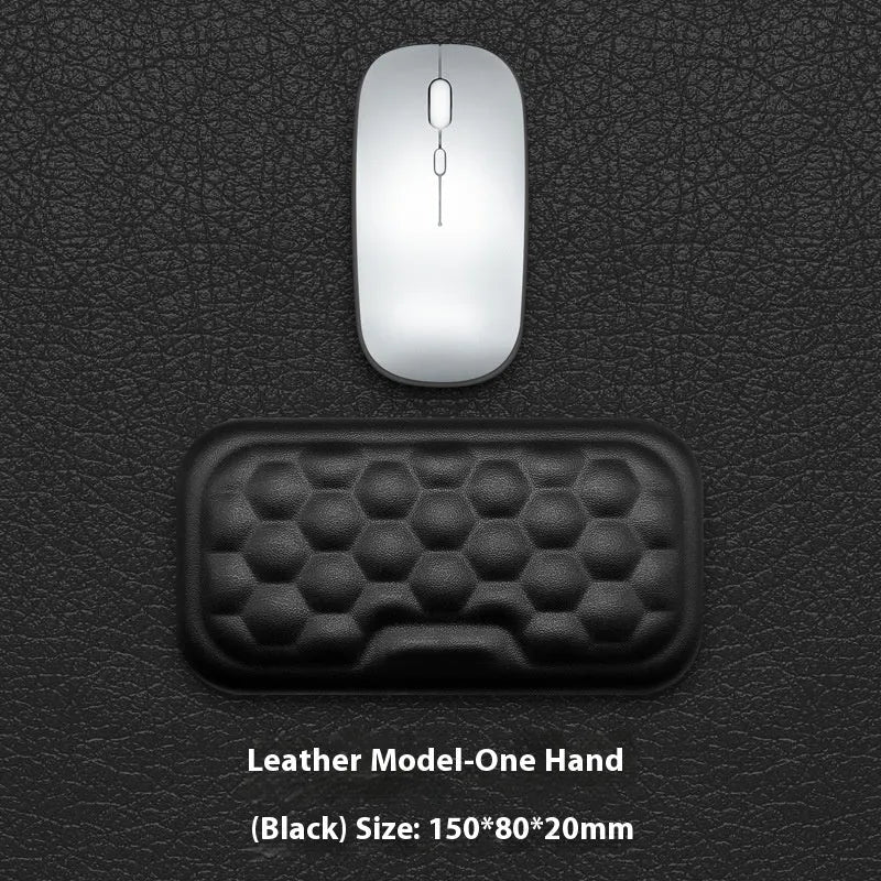 Grey and black memory foam mouse wrist rests with cloth or leather covers on a desk.